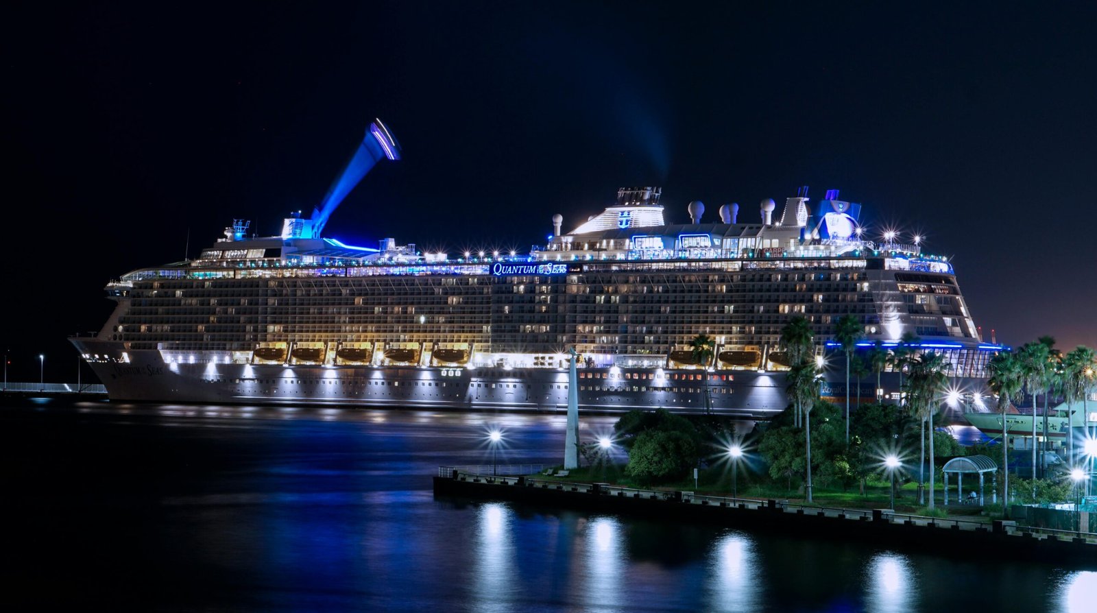 A stunning view of a cruise ship illuminated and docked at night in Fukuoka harbor.